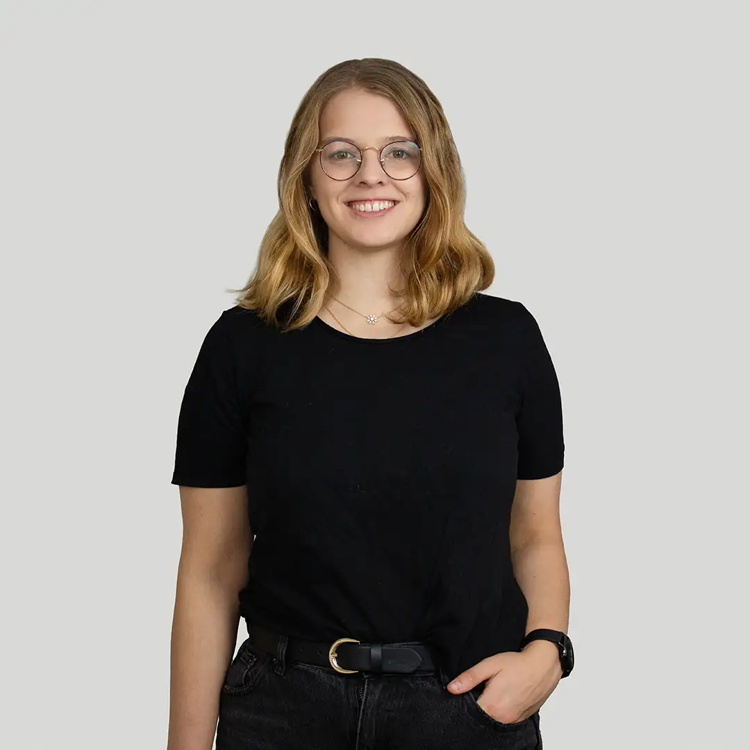 Eine junge Frau mit blonden, welligen Haaren. Sie lächelt freundlich in die Kamera